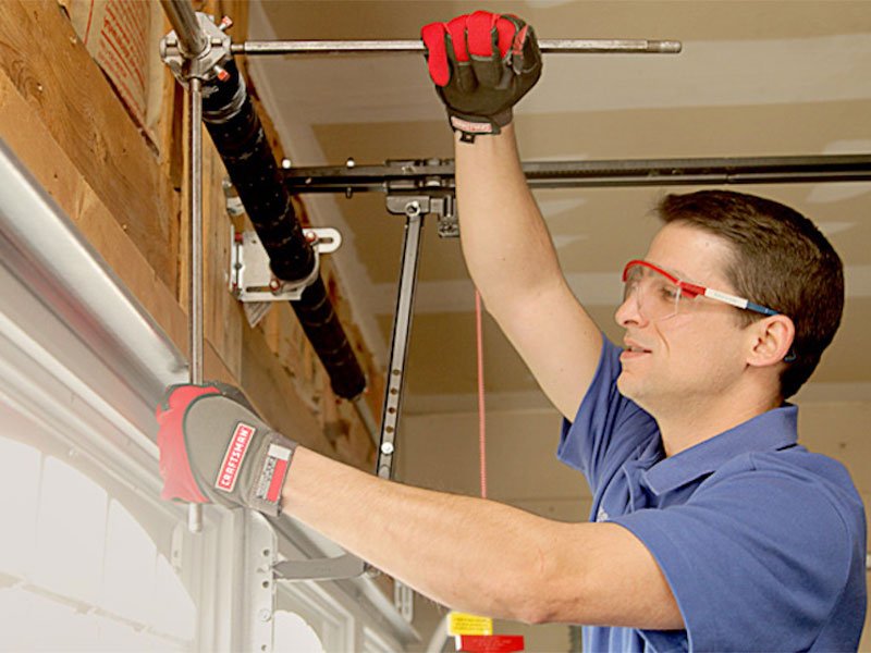 Garage door technician repairing a torsion spring